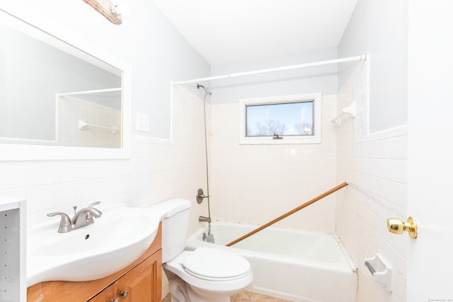 bathroom with vanity, tile walls, toilet, and shower / bathtub combination