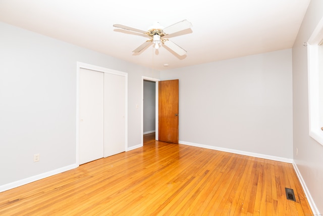 unfurnished bedroom with a closet, baseboards, and light wood-style floors