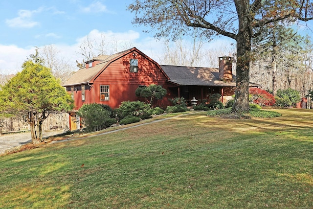 view of front of house featuring a chimney, a front lawn, and a shingled roof