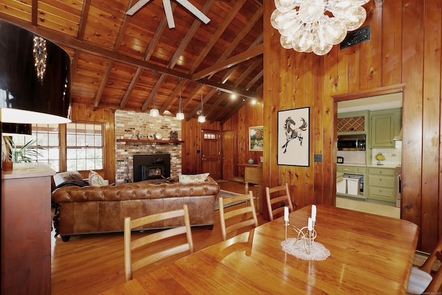 dining space featuring wooden walls, wood finished floors, visible vents, beam ceiling, and wood ceiling