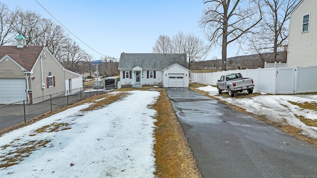 view of front of home with aphalt driveway, fence, and a garage