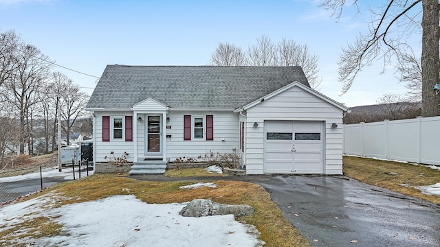 view of front of home featuring a shingled roof, fence, entry steps, driveway, and an attached garage