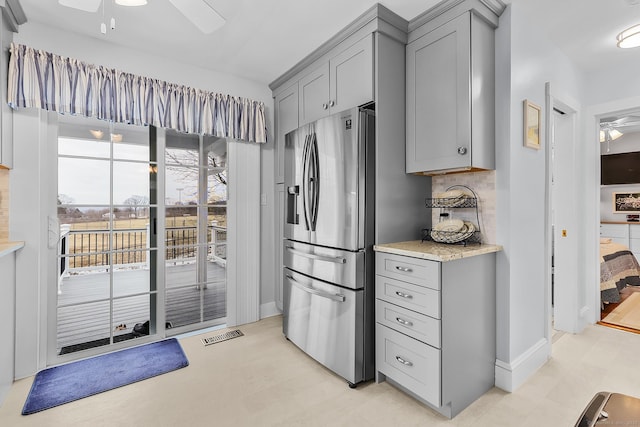 kitchen with visible vents, a ceiling fan, gray cabinetry, and stainless steel fridge with ice dispenser