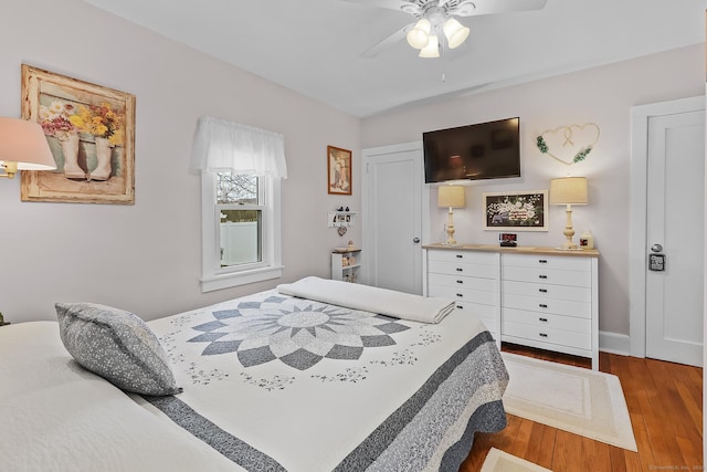 bedroom with baseboards, wood finished floors, and a ceiling fan