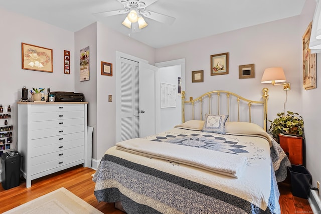 bedroom featuring a ceiling fan, wood finished floors, and a closet