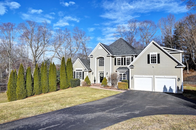 view of front facade with a garage, driveway, and a front yard