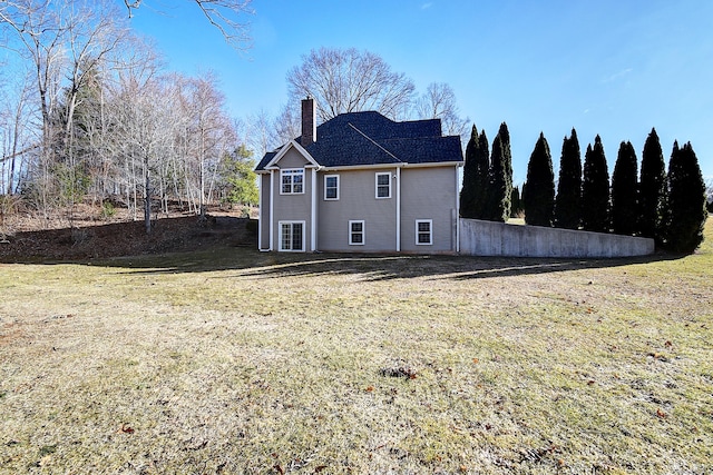 rear view of property with a lawn and a chimney