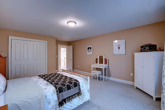 carpeted bedroom with a closet and baseboards