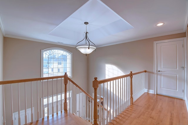 hallway with light wood finished floors, an upstairs landing, crown molding, and baseboards