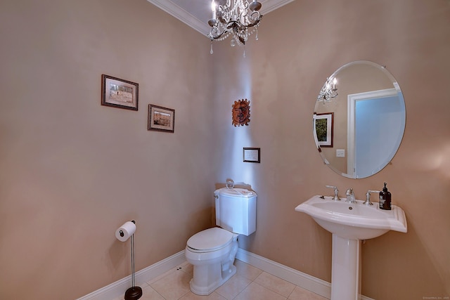 bathroom with a notable chandelier, toilet, a sink, tile patterned flooring, and baseboards