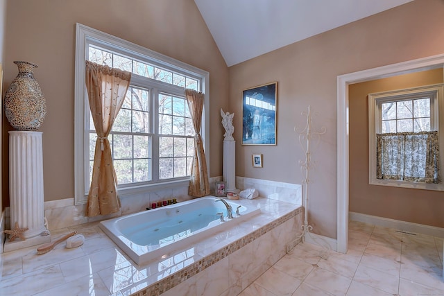 bathroom featuring vaulted ceiling, visible vents, baseboards, and a whirlpool tub