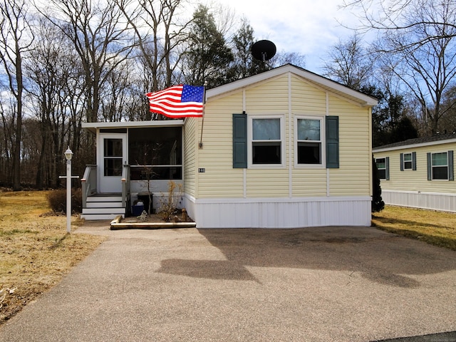 manufactured / mobile home featuring aphalt driveway and a sunroom