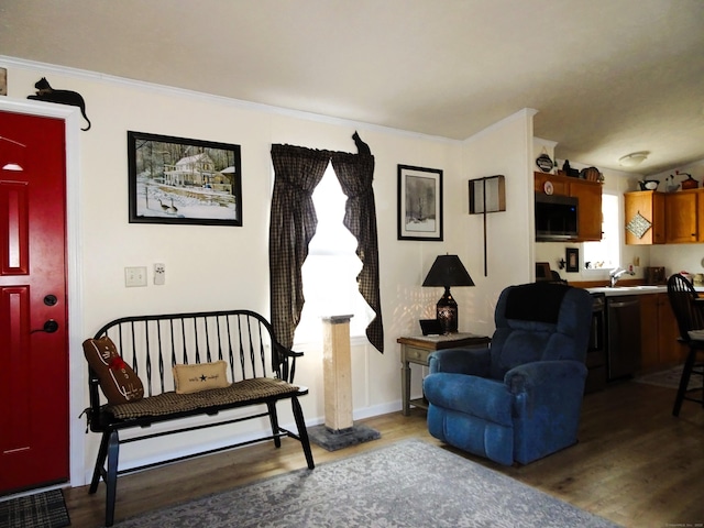 living area featuring light wood-style flooring, crown molding, and baseboards