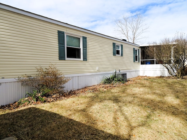 view of side of property featuring cooling unit and a lawn