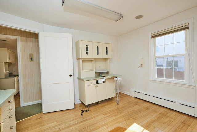 office featuring light wood-style flooring, a baseboard heating unit, and baseboards