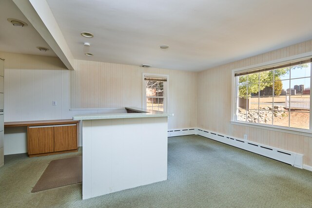 kitchen with a baseboard heating unit, light countertops, carpet, and a healthy amount of sunlight