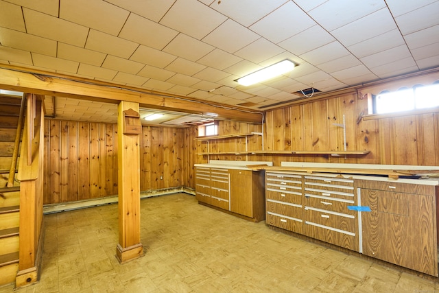 below grade area featuring stairs, wooden walls, and light floors