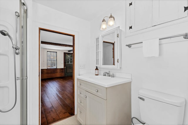 full bath with toilet, wood finished floors, and vanity