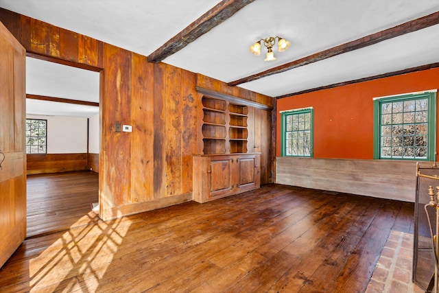 interior space featuring a wainscoted wall, beam ceiling, wooden walls, and wood-type flooring