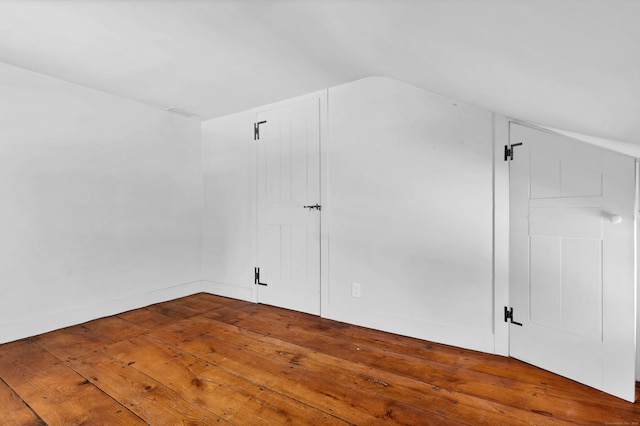 additional living space featuring lofted ceiling and hardwood / wood-style flooring