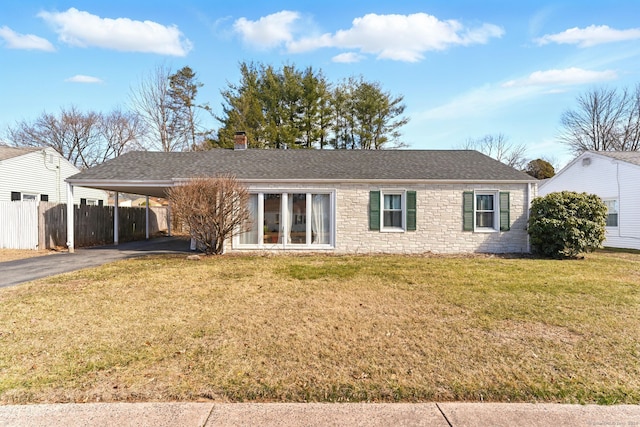 ranch-style house with an attached carport, a front yard, fence, driveway, and stone siding