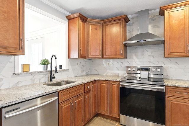 kitchen featuring tasteful backsplash, crown molding, wall chimney range hood, stainless steel appliances, and a sink