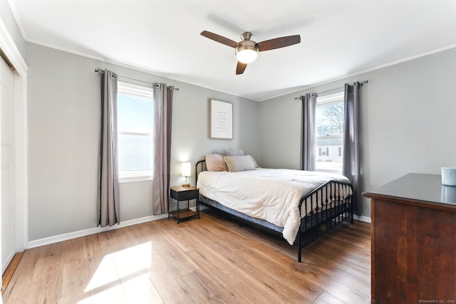 bedroom with baseboards, a ceiling fan, wood finished floors, and crown molding