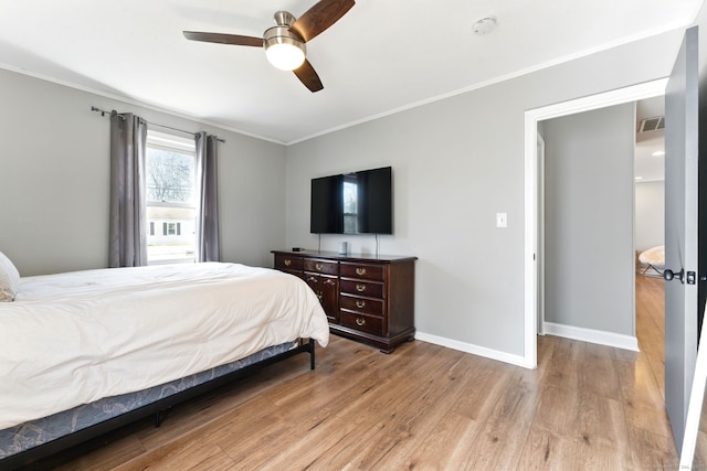 bedroom featuring light wood-style flooring, a ceiling fan, baseboards, and ornamental molding