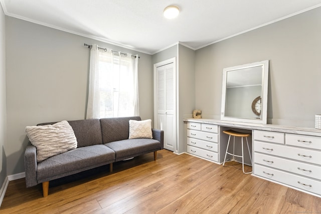 sitting room featuring built in study area, light wood-type flooring, and ornamental molding