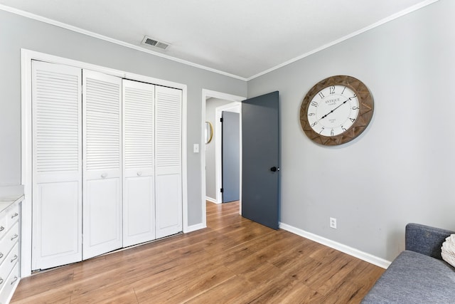 living area featuring crown molding, light wood-style floors, visible vents, and baseboards