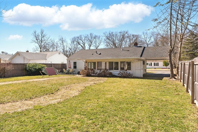 rear view of house featuring a lawn, a patio, a chimney, and a fenced backyard