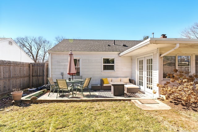 back of house featuring a lawn, a patio, a fenced backyard, french doors, and a chimney