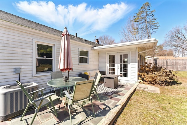 view of patio / terrace featuring central AC unit, french doors, outdoor dining area, and fence