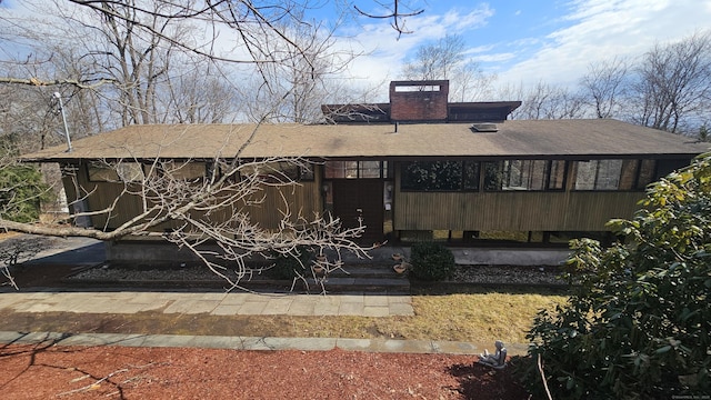 rear view of house featuring a chimney