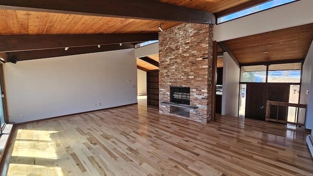 unfurnished living room featuring lofted ceiling with beams, wood finished floors, wooden ceiling, and a fireplace