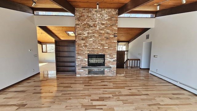 unfurnished living room featuring beam ceiling, visible vents, wooden ceiling, and a baseboard heating unit