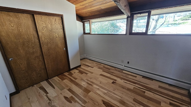 unfurnished bedroom with a baseboard heating unit, wood finished floors, a closet, lofted ceiling, and wood ceiling