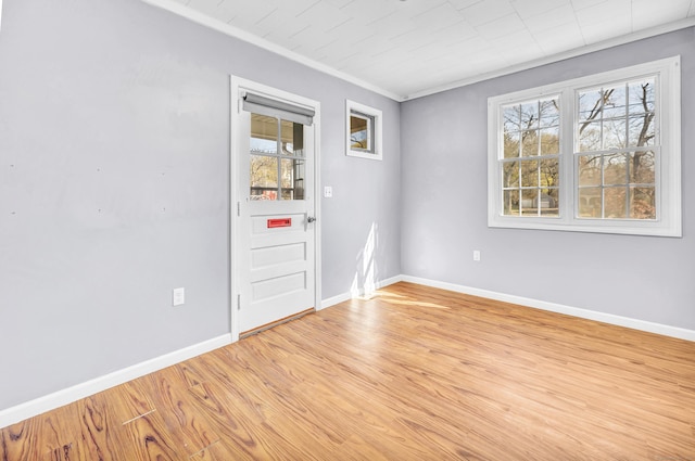 empty room with baseboards, light wood-style floors, and ornamental molding