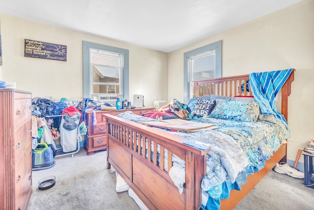 bedroom with radiator, multiple windows, and carpet floors