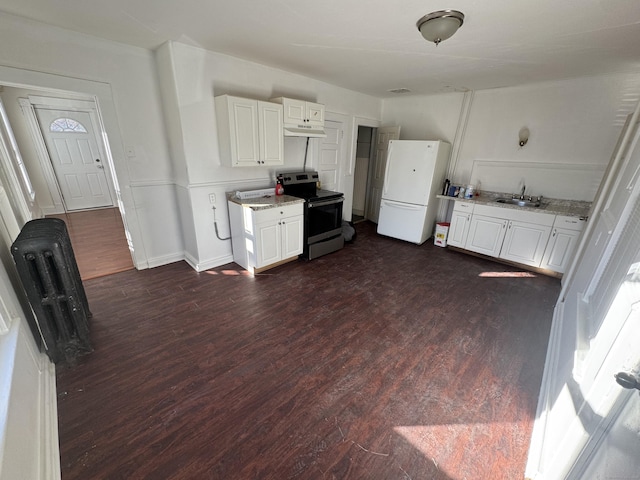 kitchen featuring dark wood-type flooring, under cabinet range hood, a sink, freestanding refrigerator, and stainless steel electric range