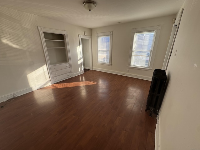 unfurnished bedroom with dark wood-type flooring and baseboards