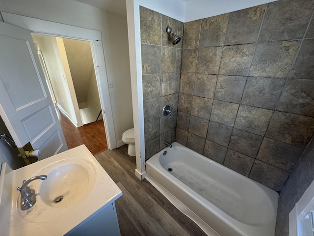 bathroom with baseboards, toilet, bathtub / shower combination, wood finished floors, and vanity