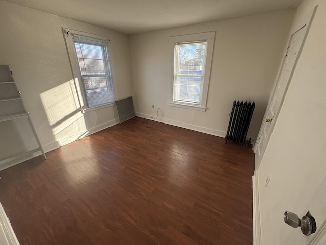 interior space featuring radiator, dark wood-style floors, and baseboards