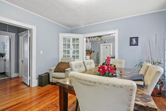 dining space featuring crown molding and wood finished floors