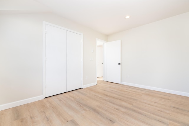 unfurnished bedroom with recessed lighting, a closet, baseboards, and light wood finished floors