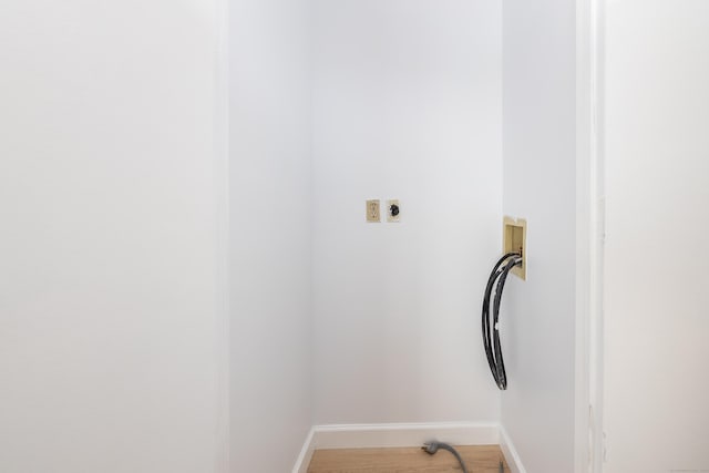 laundry area with laundry area, hookup for a washing machine, light wood-style floors, and baseboards