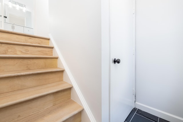 staircase featuring baseboards and tile patterned flooring