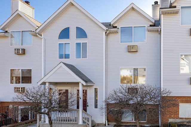 multi unit property with an AC wall unit and roof with shingles