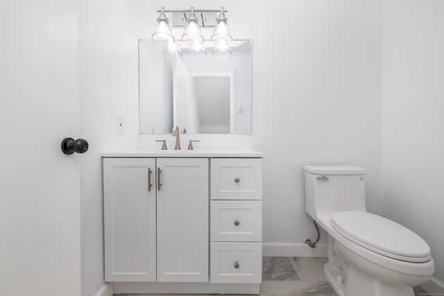 bathroom featuring baseboards, toilet, marble finish floor, and vanity