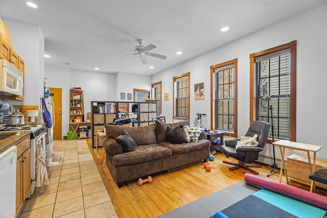 living room featuring a ceiling fan, light tile patterned floors, recessed lighting, and baseboard heating